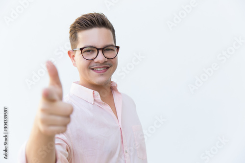 Happy joyful professional pointing index finger at camera. Young man in glasses standing isolated over white background. Career concept