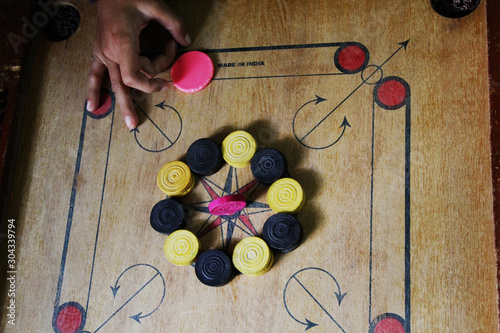 A game of carrom with pieces carrom man on the board carrom.Carom board game, selective focus.