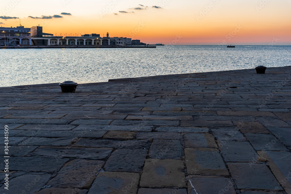 Sunset from the Audace pier of Trieste. Colors of fire on the water. Italy