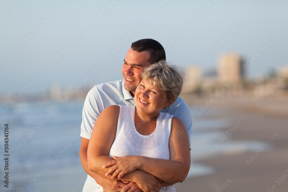 Portrait of a happy lovers husband and wife. Couple walks along the sea at sunrise