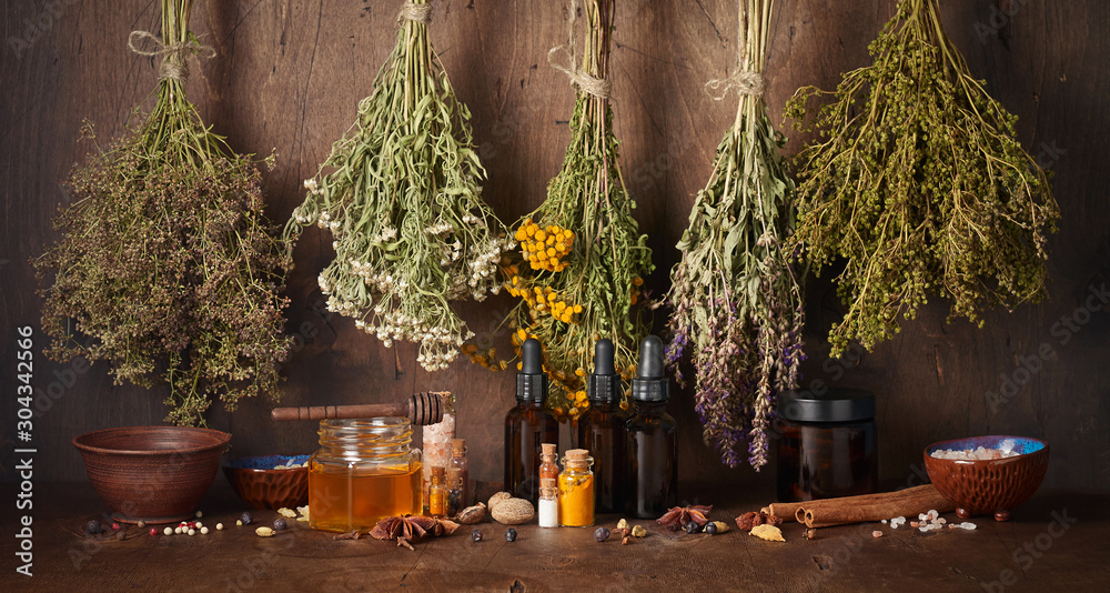 Drying medical herbs, honey, spices and bottle with essential oil for use in alternative medicine
