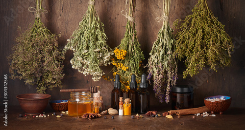Drying medical herbs, honey, spices and bottle with essential oil for use in alternative medicine