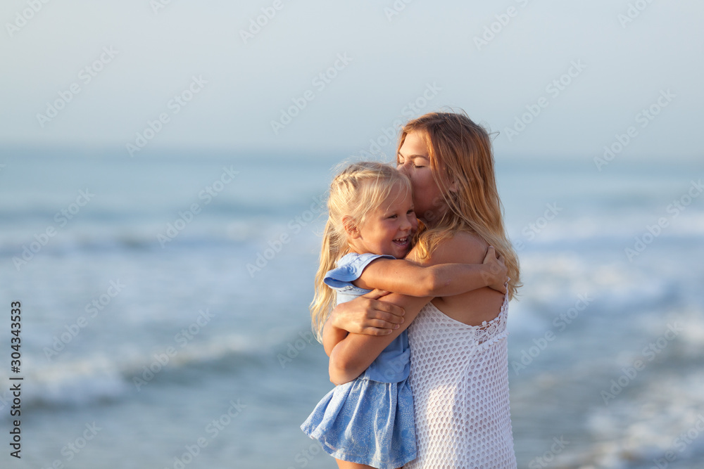 Portrait of happy sisters. They hug on the background of the sea. Portrait of happy sisters. They hug on the background of the sea.