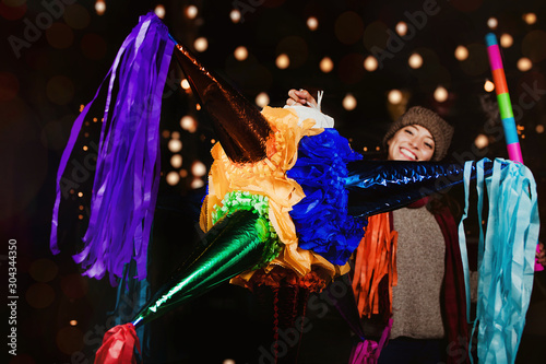 Mexican Colorful Piñata, Woman Holding a colorful Piñata celebrating  Christmas in a traditional Posada in Mexico City
