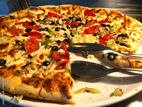 Food background. Freshly baked pizza on the table without one piece. Horizontal, close-up, cropped shot. Food concept.