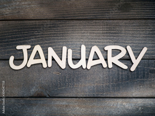 The name of the month is composed of light wooden letters on dark wood. The month of January. 