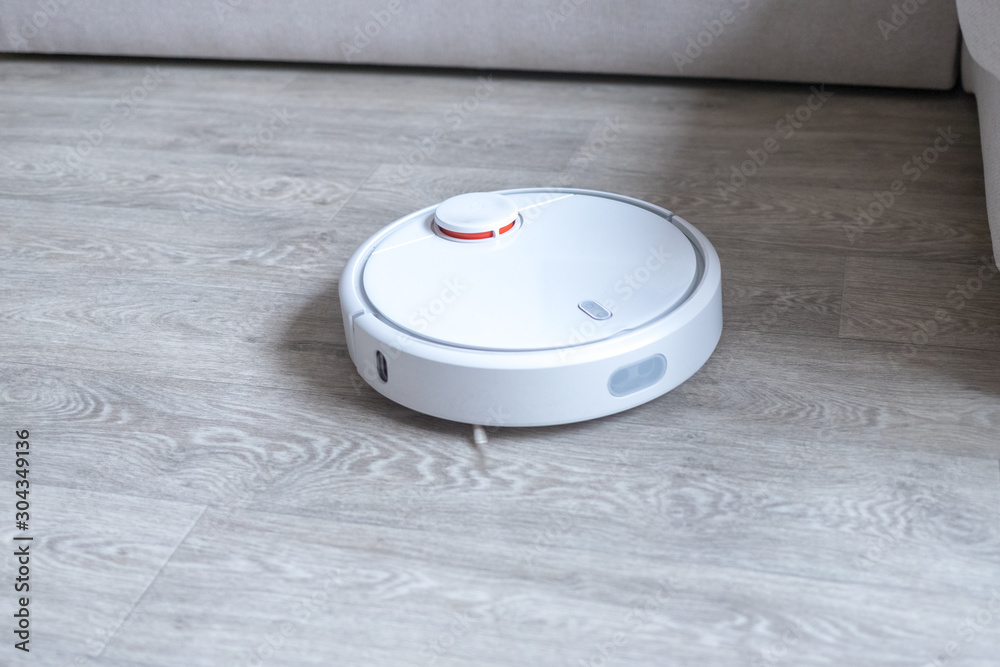 Robotic vacuum cleaner on the floor cleaning the room. Smart cleaning technology. Robotic vacuum cleaner on the floor cleaning the room. Smart cleaning technology.