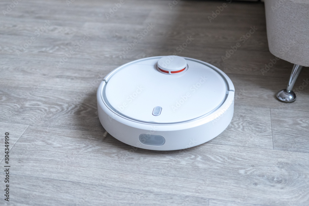 Robotic vacuum cleaner on the floor cleaning the room. Smart cleaning technology. Robotic vacuum cleaner on the floor cleaning the room. Smart cleaning technology.