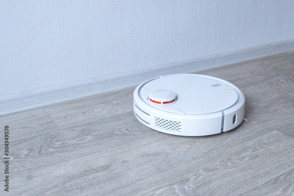 Robotic vacuum cleaner on the floor cleaning the room. Smart cleaning technology. Robotic vacuum cleaner on the floor cleaning the room. Smart cleaning technology.