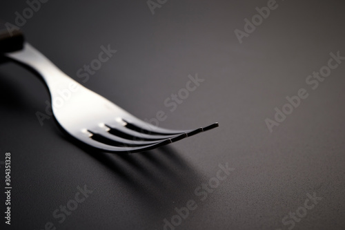 Table fork on black background 
