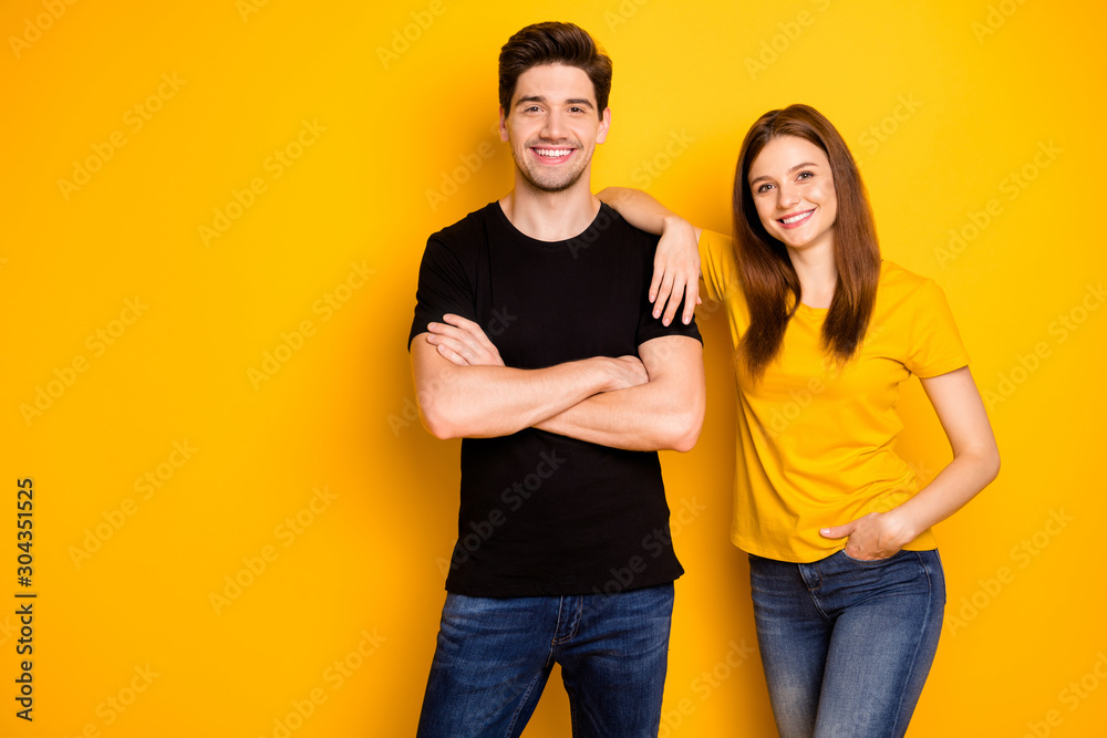 Photo of cheerful nice cute pretty beautiful couple of two people standing confidently in black t-shirt jeans denim arms crossed hand in pocket smile toothily isolated vibrant shiny color background - obrazy, fototapety, plakaty 