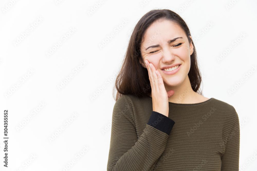 Frustrated woman with pain grimace touching cheek. Young woman in casual standing isolated over white background. Suffering from toothache concept Frustrated woman with pain grimace touching cheek. Young woman in casual standing isolated over white background. Suffering from toothache concept