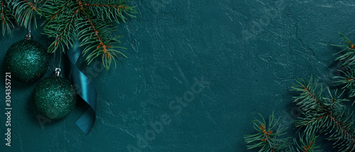 Fir branches and Christmas or New Year banner on the textured dark emerald background