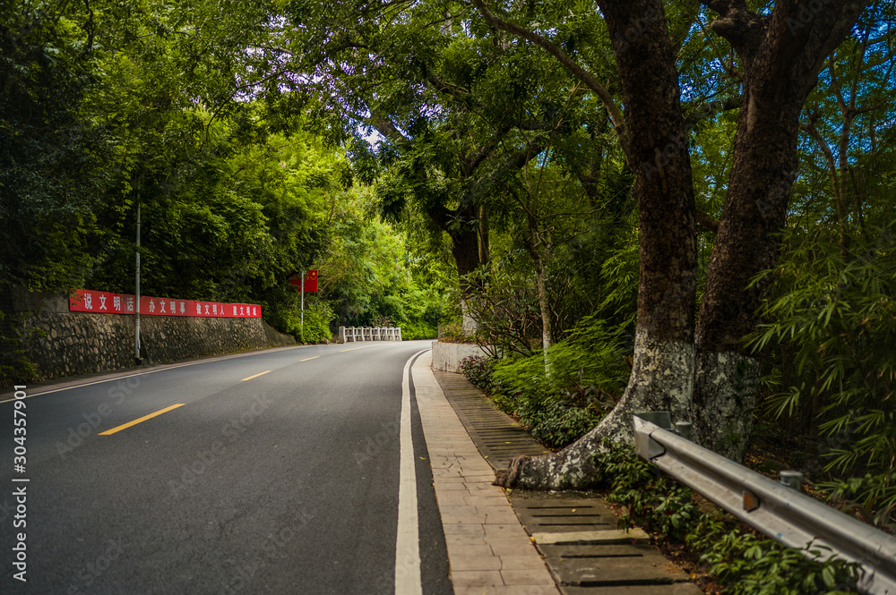 Sanya, Hainan, China - 11.06.2019. Tropical highway road with chinese flag