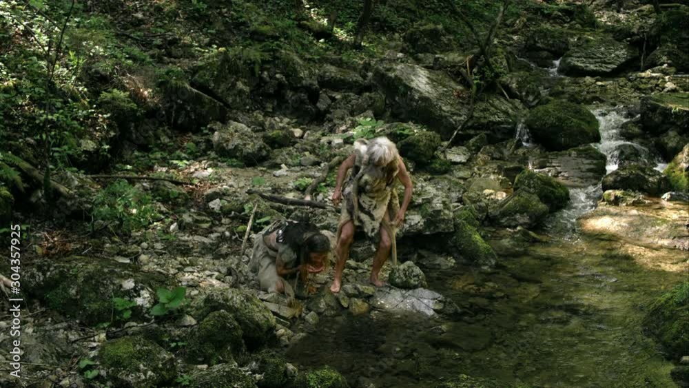 Slow Mo Cavemen Drink From Stream And Exclaim Happily Slow Mo Cavemen Drink From Stream And Exclaim Happily