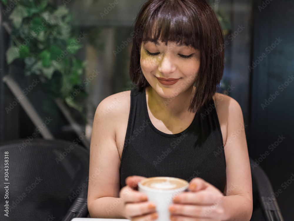 Beautiful young girl drinks coffee at cafe Beautiful young girl drinks coffee at cafe