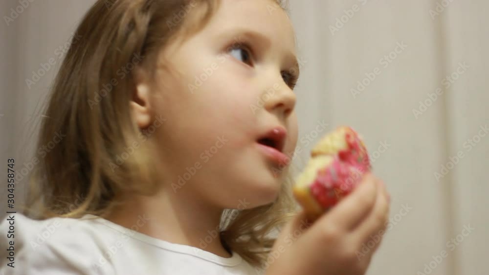 Child mouth bites rose donut. Closeup baby girl eating doughnut with glase. Delicious, sweet, sweettooth Child mouth bites rose donut. Closeup baby girl eating doughnut with glase. Delicious, sweet, sweettooth