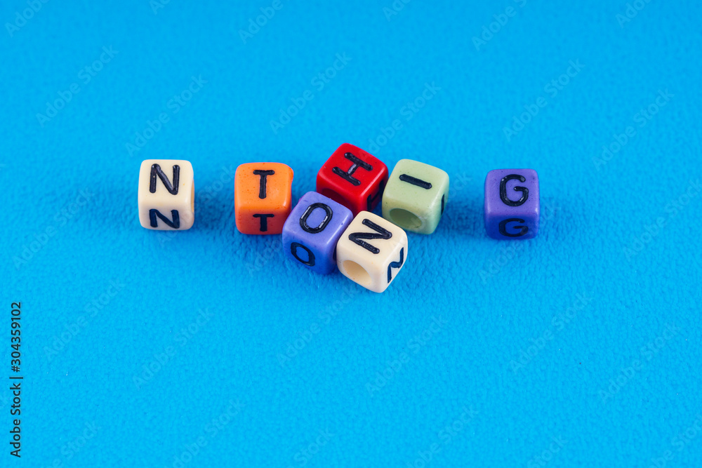 A word NOTHING made by a colourful cube beads alphabet over blue background. A word NOTHING made by a colourful cube beads alphabet over blue background.