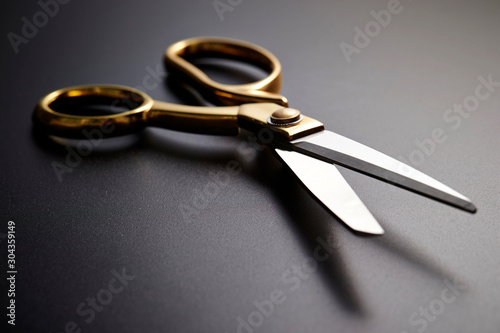 Gold handle scissors on black background 