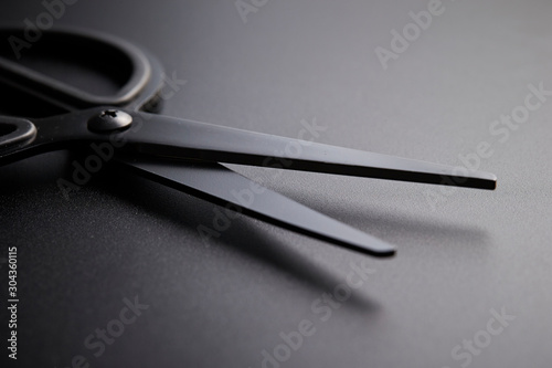 Full black scissors on black background 