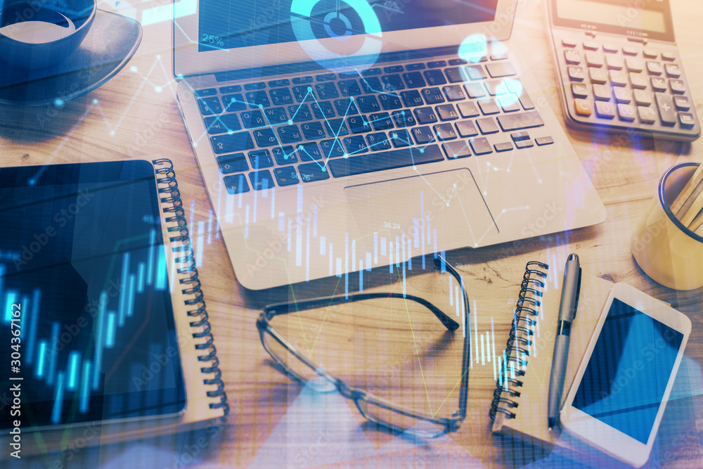 Forex Chart hologram on table with computer background. Double exposure. Concept of financial markets. Forex Chart hologram on table with computer background. Double exposure. Concept of financial markets.