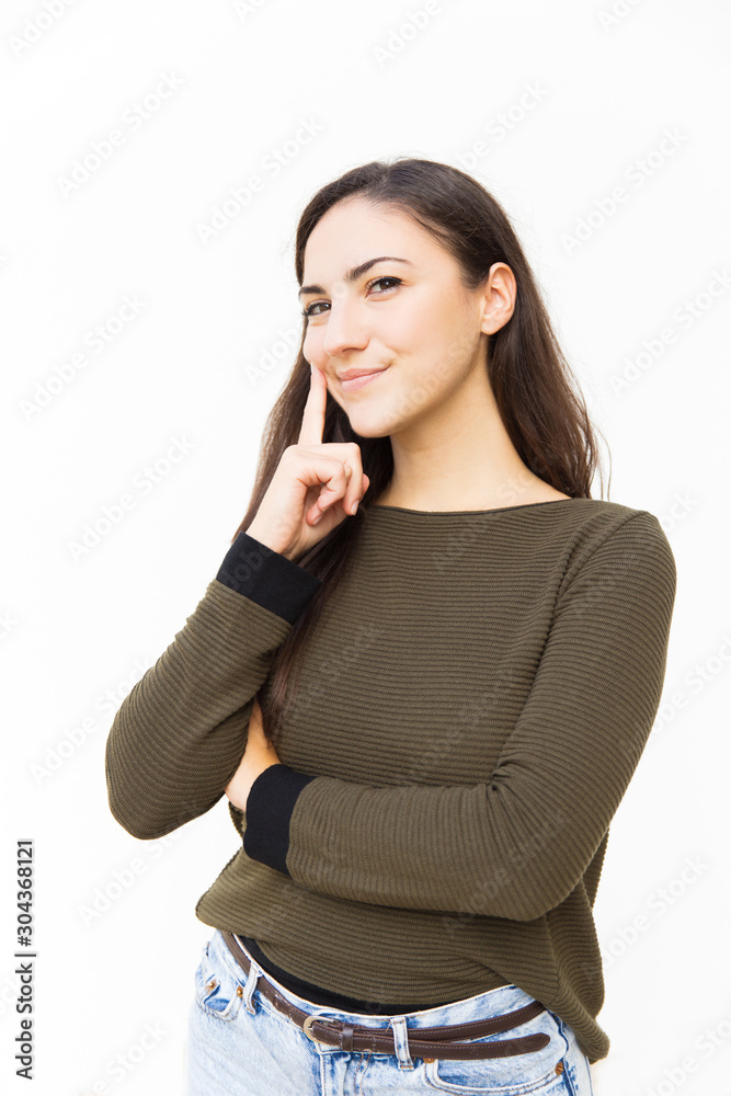 Positive pensive female student touching face with finger and thinking over decision. Young woman in casual standing isolated over white background. Decision making concept Positive pensive female student touching face with finger and thinking over decision. Young woman in casual standing isolated over white background. Decision making concept