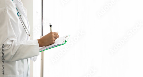 The doctor made a review of the patient charts. writing on a medical chart with patient