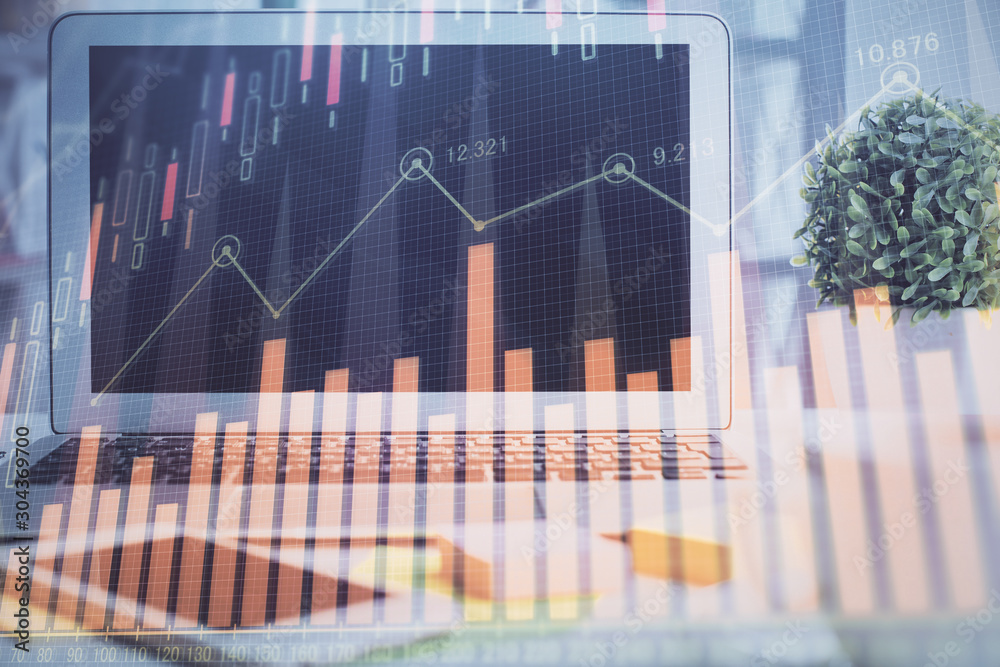 Financial chart drawing and table with computer on background. Double exposure. Concept of international markets. Financial chart drawing and table with computer on background. Double exposure. Concept of international markets.