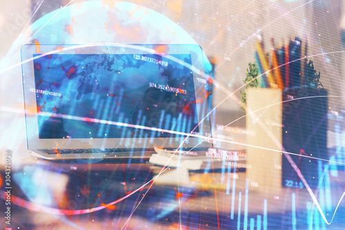 Stock market graph on background with desk and personal computer. Double exposure. Concept of financial analysis.