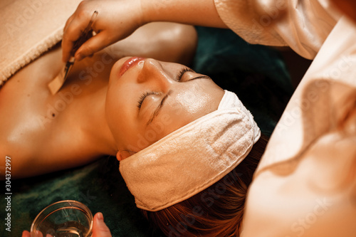 Beautiful caucasian woman resting while having skin care procedures in a wellness spa salon. photo