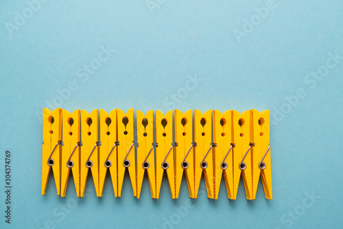 yellow plastic clothespins on blue background