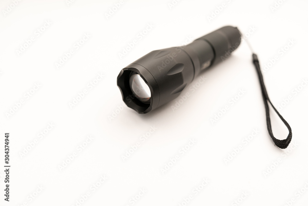 black battery-powered flashlight on white background black battery-powered flashlight on white background