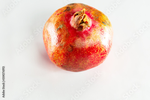 Very ripe pomegranate on white isolated background closeup.