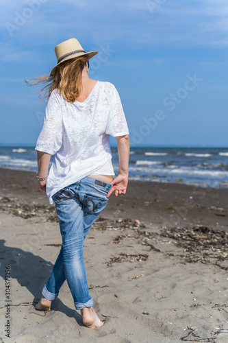 beautiful happy woman at the seaside, sexually walking in the sand