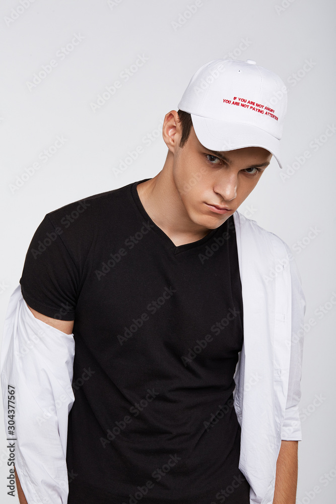 Cropped front view shot of a dark-haired man, wearing white baseball cap with lettering Cropped front view shot of a dark-haired man, wearing white baseball cap with lettering