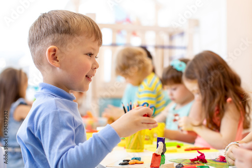 Preschool child on lesson in classroom. Kids group hands crafting in kindergarten