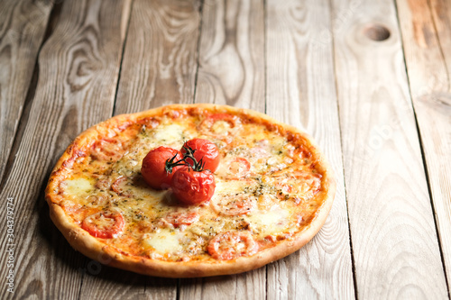 Traditional italian pizza with tomatoes, cheese, ham, mushrooms on a light rustic background photo