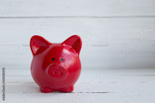 Red pig piggy bank on white wooden background