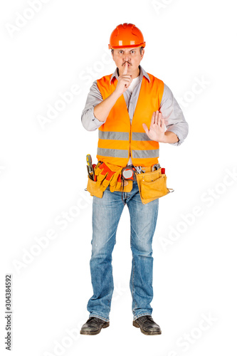 Portrait of a male builder in a helmet looking at camera over white wall background. repair, construction, building, people and maintenance concept.