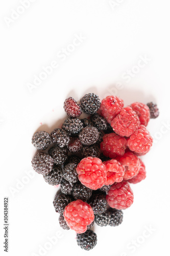 Red and black raspberries closeup on a white background.