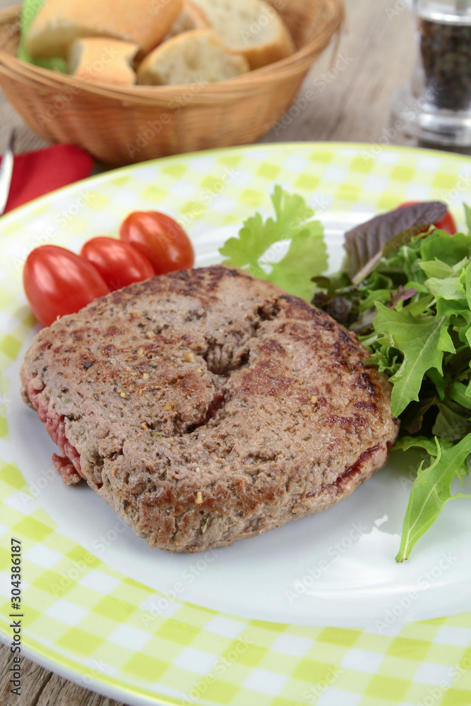 grilled ground beef steak and salad on a plate
