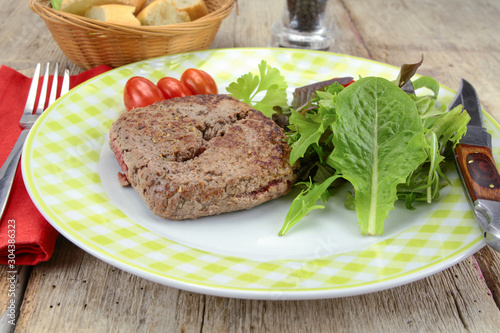 grilled ground beef steak and salad on a plate