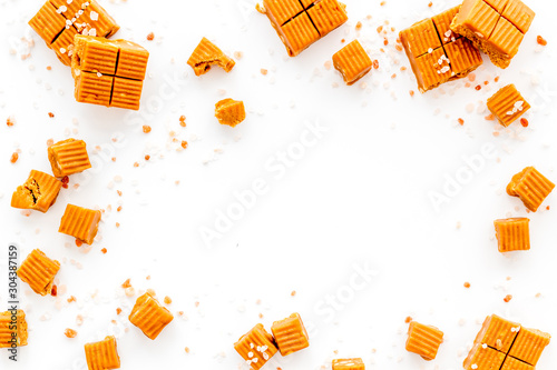 Photography Salted caramel pieces - paradoxical sweets - on white background top view frame
