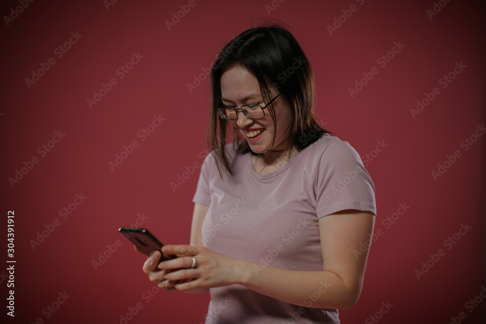 The joyful girl looks at her gadget with a laugh. The joyful girl looks at her gadget with a laugh.