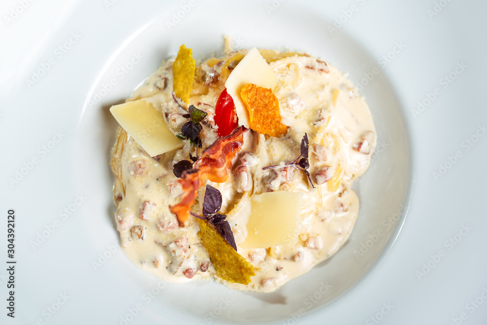 Potato gnocchi pasta with cheese sauce ham and basil on a plate. Potato gnocchi pasta with cheese sauce ham and basil on a plate.