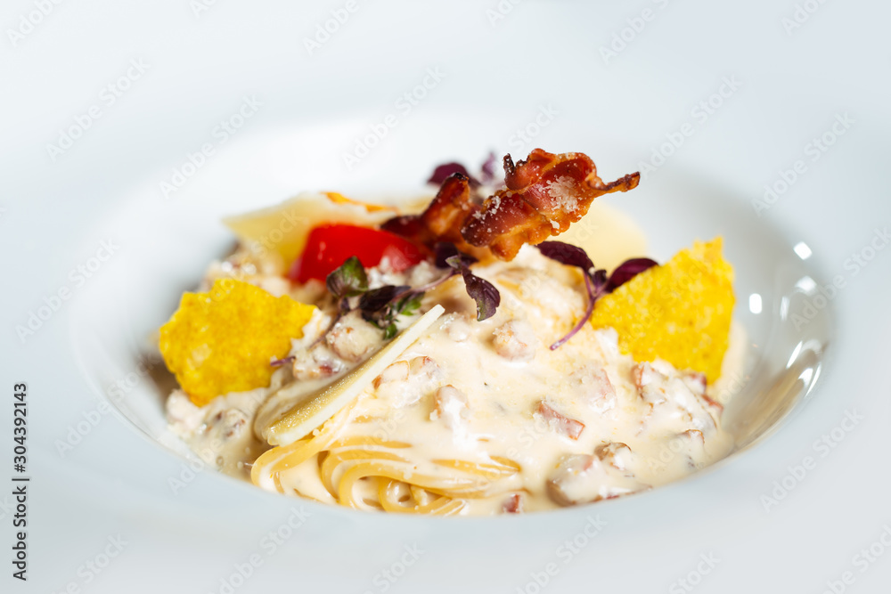 Potato gnocchi pasta with cheese sauce ham and basil on a plate. Potato gnocchi pasta with cheese sauce ham and basil on a plate.