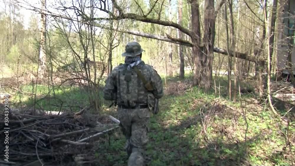 Moscow, Russia - May 09, 2013: Men in military uniforms playing on airsoft military polygon in the forest. People using a copy of a firearm.
