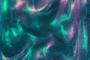 Abstract elegant, trendy detailed mint and pink glitter particles flow with shallow depth of field underwater. Holiday magic shimmering luxury background. Festive sparkles and lights. de-focused.
