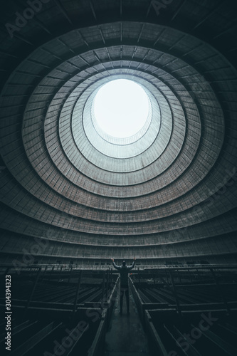 Figure standing inside abandoned cooling tower