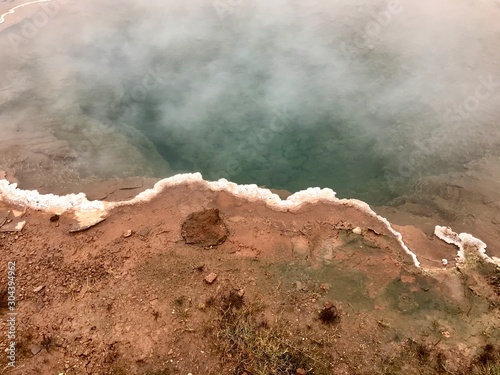 The Konungshver Geyser, part of Haukadalur, the home of geysers and other geothermal features along the Golden Circle tourist route in southern Iceland on a foggy autumn afternoon photo